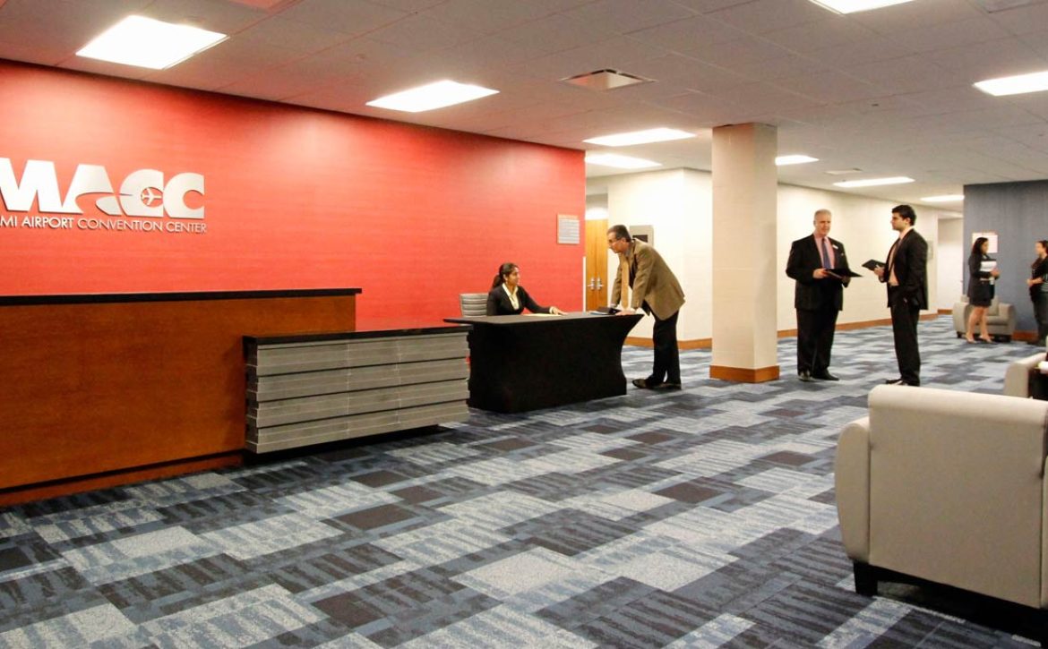 Business attendees checking in at the Miami Airport Convention Center (MACC) reception desk near MIA