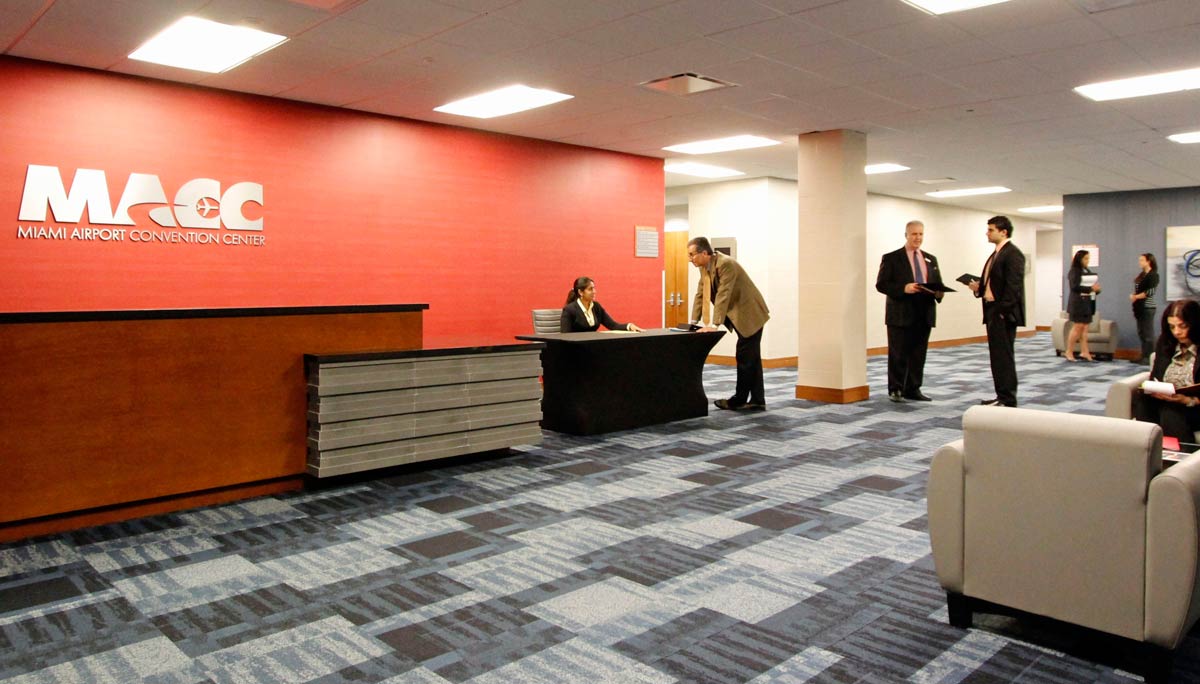 Business attendees checking in at the Miami Airport Convention Center (MACC) reception desk near MIA